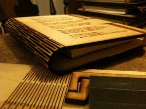 a photo showing a wooden notebook with a laser cut hinge