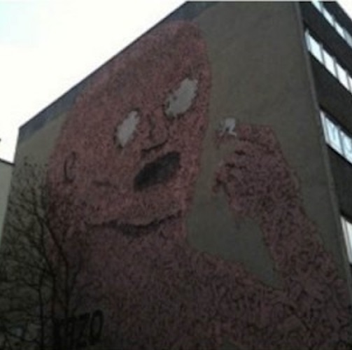graffiti on a huge building of a person with white eyes