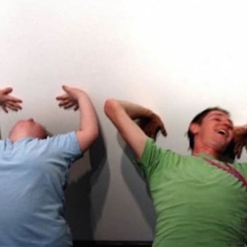 image of participants leaning back against the wall laughing