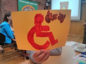 a photo of someone holding up the accessible wheelchair sign to the camera