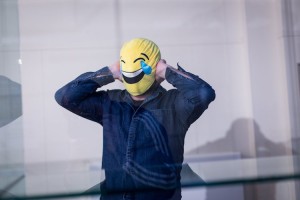 a man with a laughing emoticon mask over his head