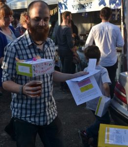 a man balancing a decorated box on a pint of beer