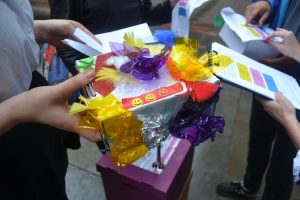 a decorated box covered in tin foil, coloured paper and smiley faces