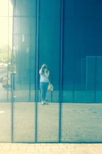 image of mirrored wall reflecting the image of jenny taking a photograph